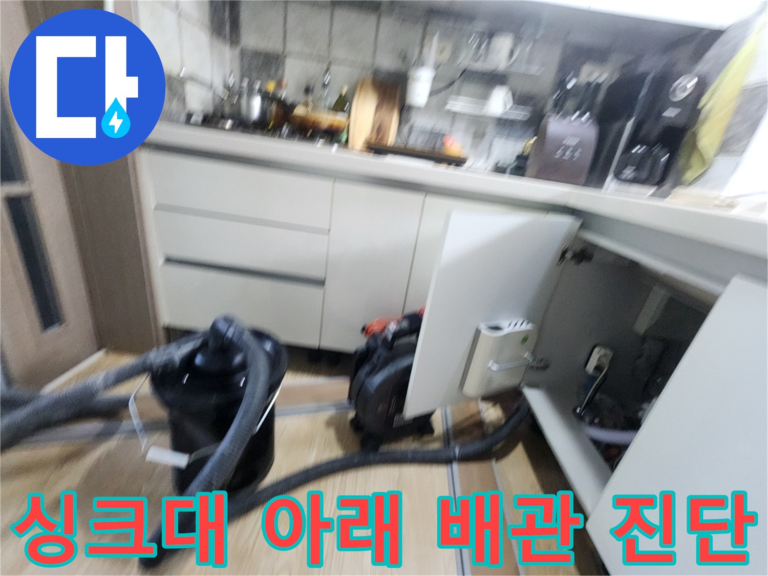 주방 하부장 하단 공간에 배치된 누수 탐지용 장비와 배관 주변 모습