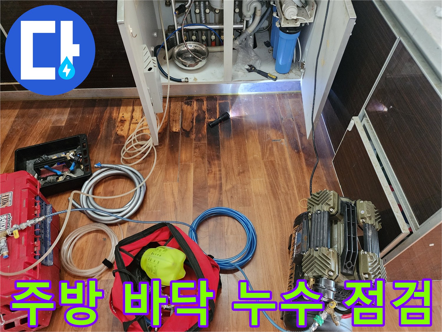 싱크대 하부장 아래 원인을 찾기 위해 공압 장비를 배치한 모습