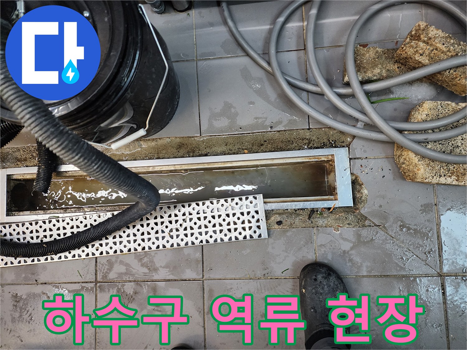 트렌치 내부의 오염된 물과 주변 바닥 타일 상태 - 배관 점검 단계