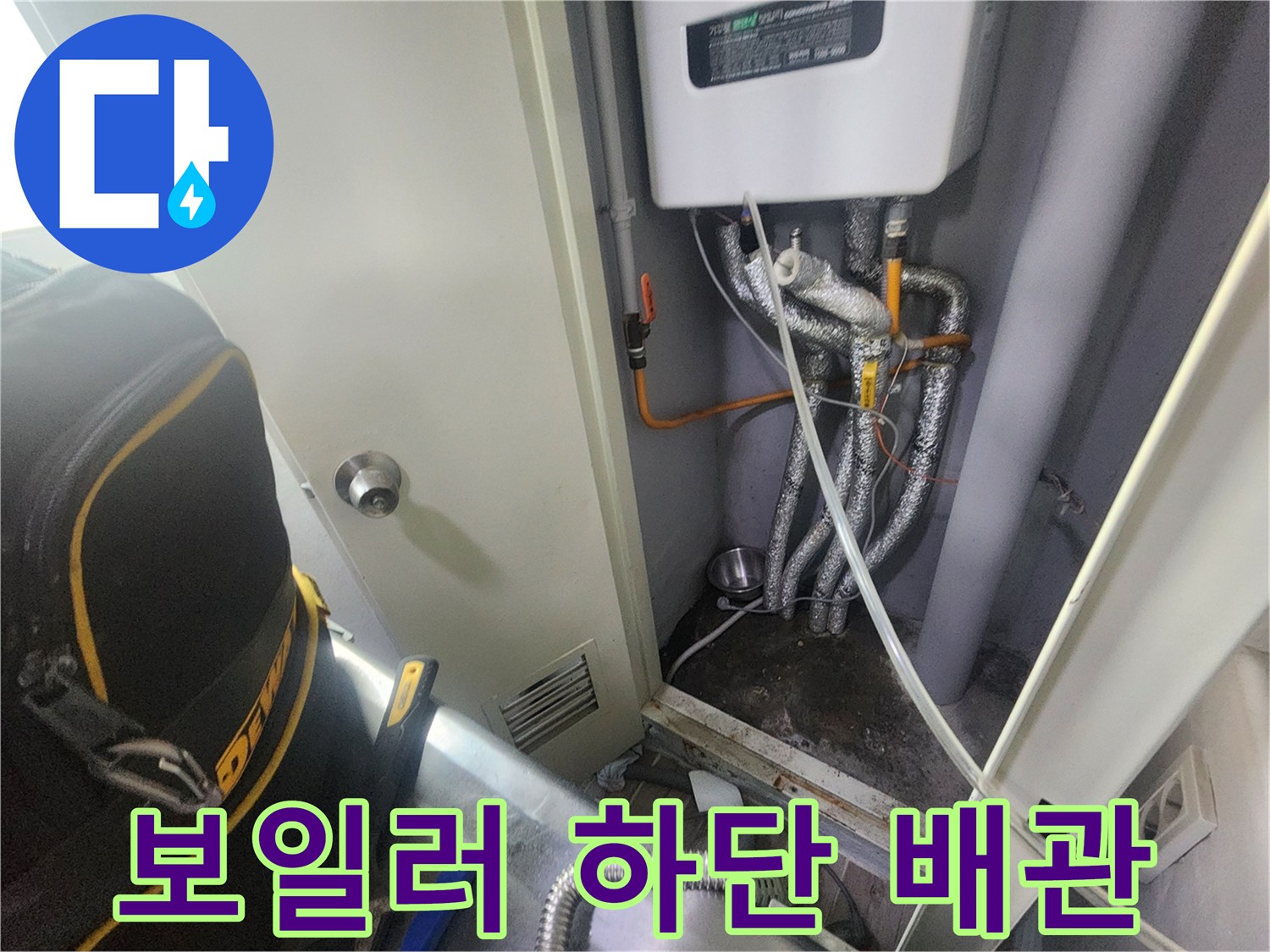 흰색 보일러 장비와 연결된 은색 보온재 마감 배관의 근접 촬영