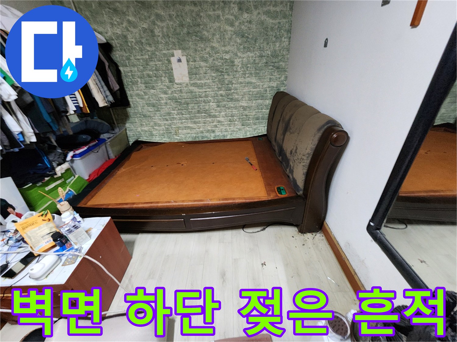 침대 옆 벽지 끝부분-물기로 인해 눅눅해진 벽면과 바닥의 경계