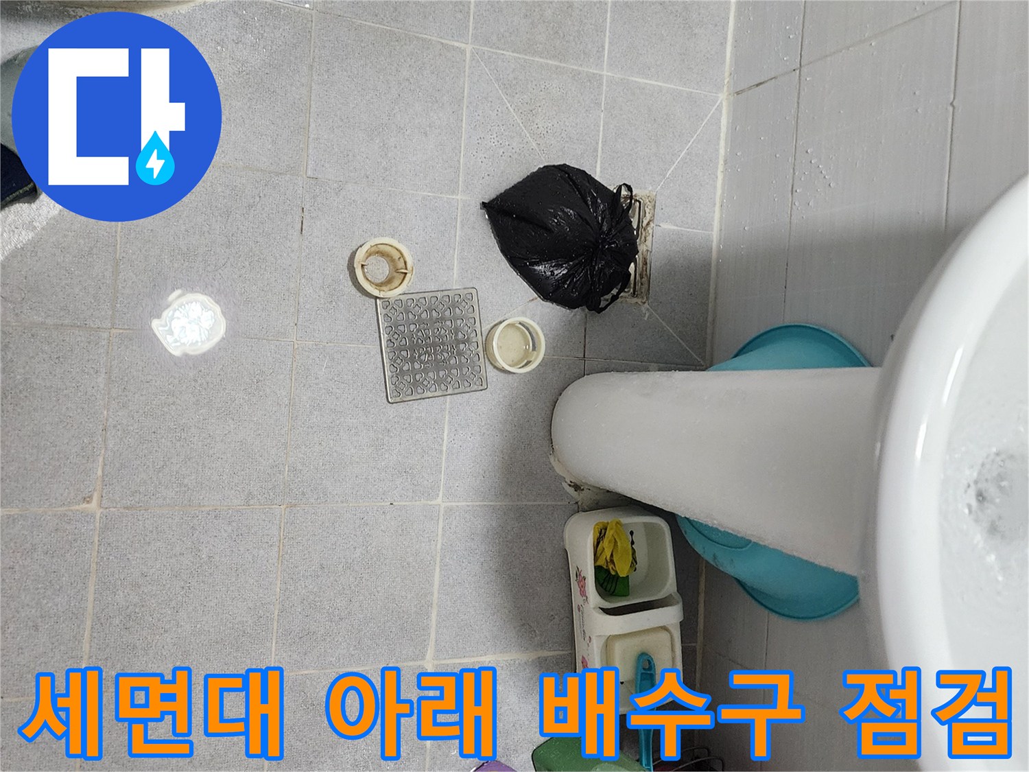세면대 밑 화장실 바닥의 배수구 부품과 타일 상태 사진
