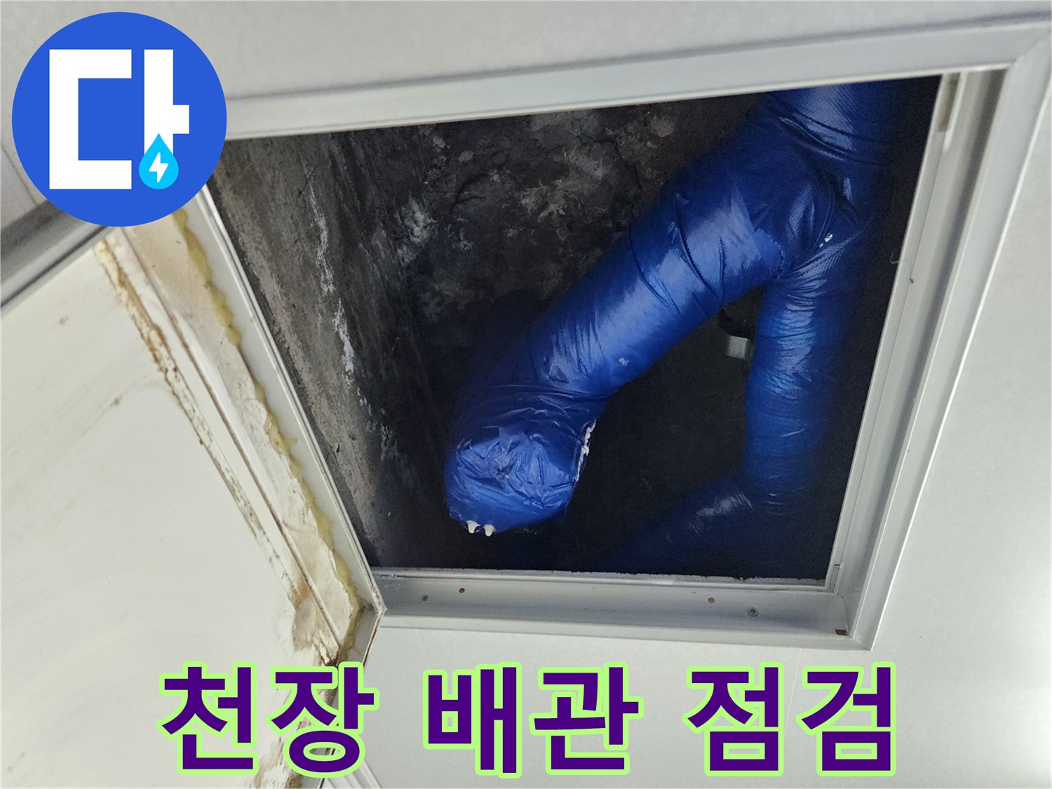 천장 점검구 내부의 파란색 보온재로 감싸진 배관 모습