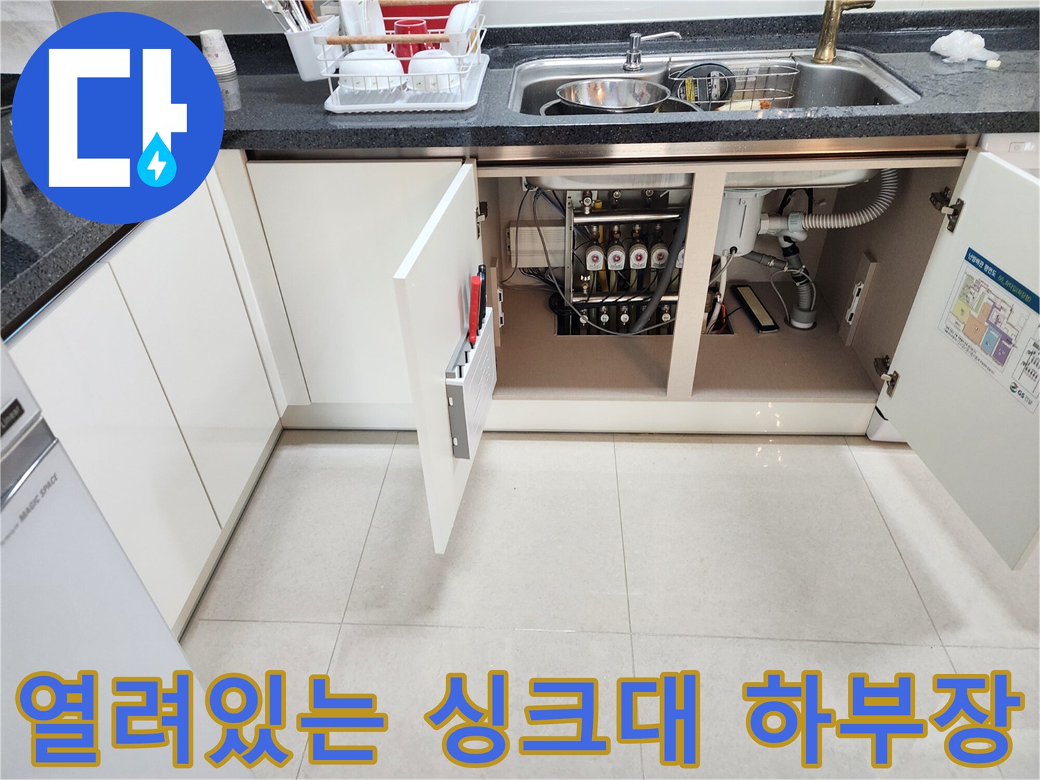 싱크대 하부장 내부의 배수 호스와 연결된 배관 구조