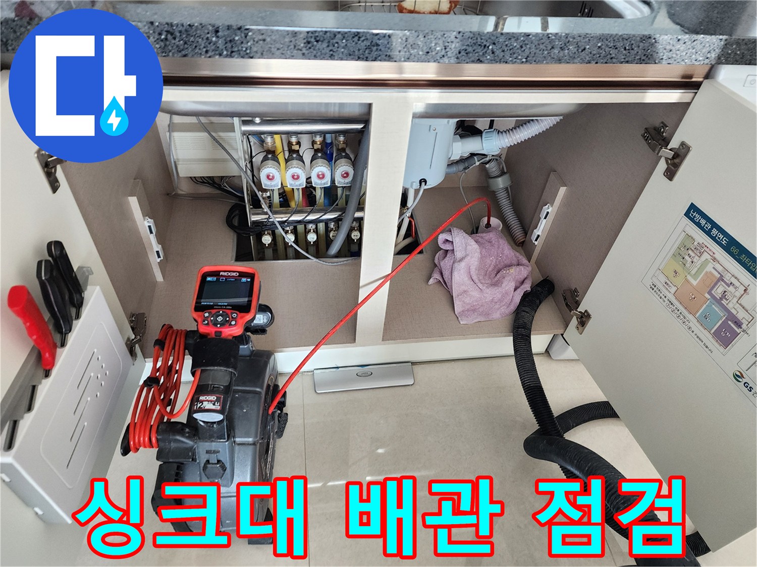 싱크대 하부장 내부의 복잡한 배관 구조와 내시경 장비 배치