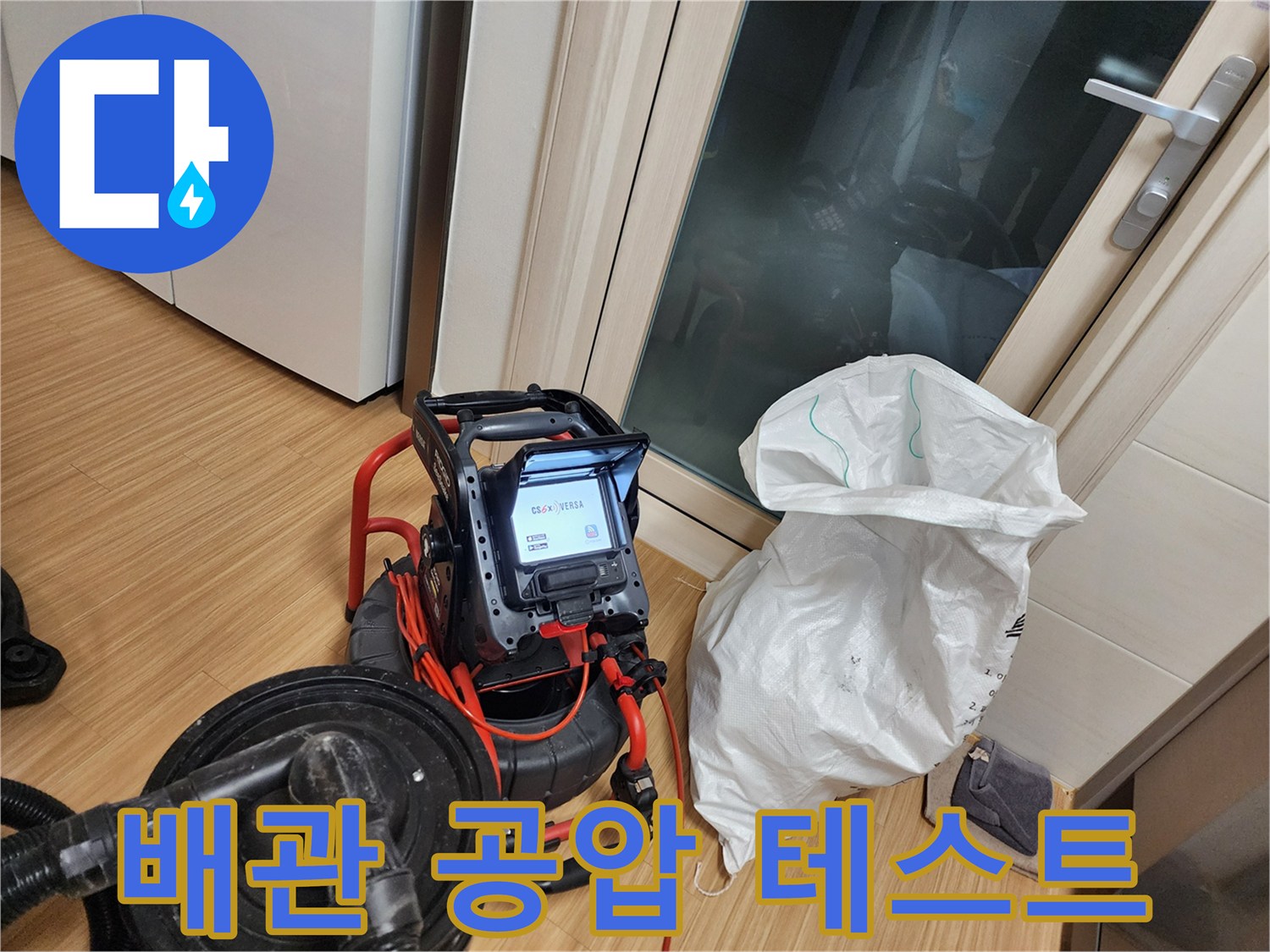 싱크대 하부 배관의 기밀 상태를 측정하기 위해 설치된 압력계와 호스입니다.