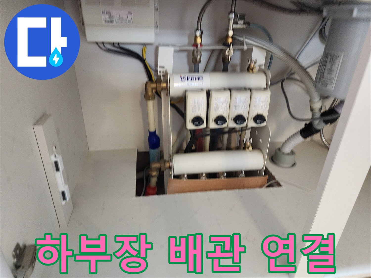 싱크대 하부에 노출된 다수의 급수 밸브와 배관 라인입니다.