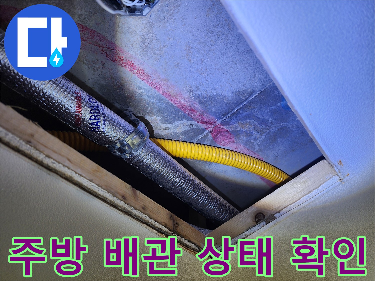 싱크대 하부의 은색 보온재 배관과 노란색 주름관이 보이는 현장 모습