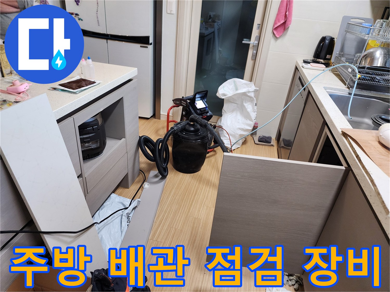싱크대 하부장 근처에 설치된 누수 탐지용 공압 테스트 장비와 호스
