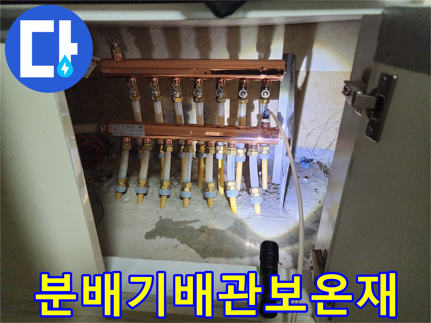 싱크대 하부장 내부의 구리 분배기와 보온 마감된 배관들