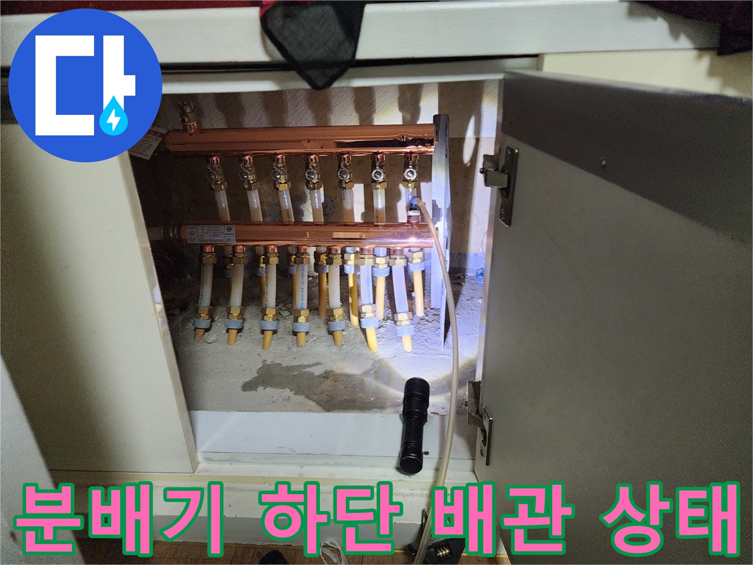 싱크대-하부장에-노출된-금속-분배기와-연결된-배관들