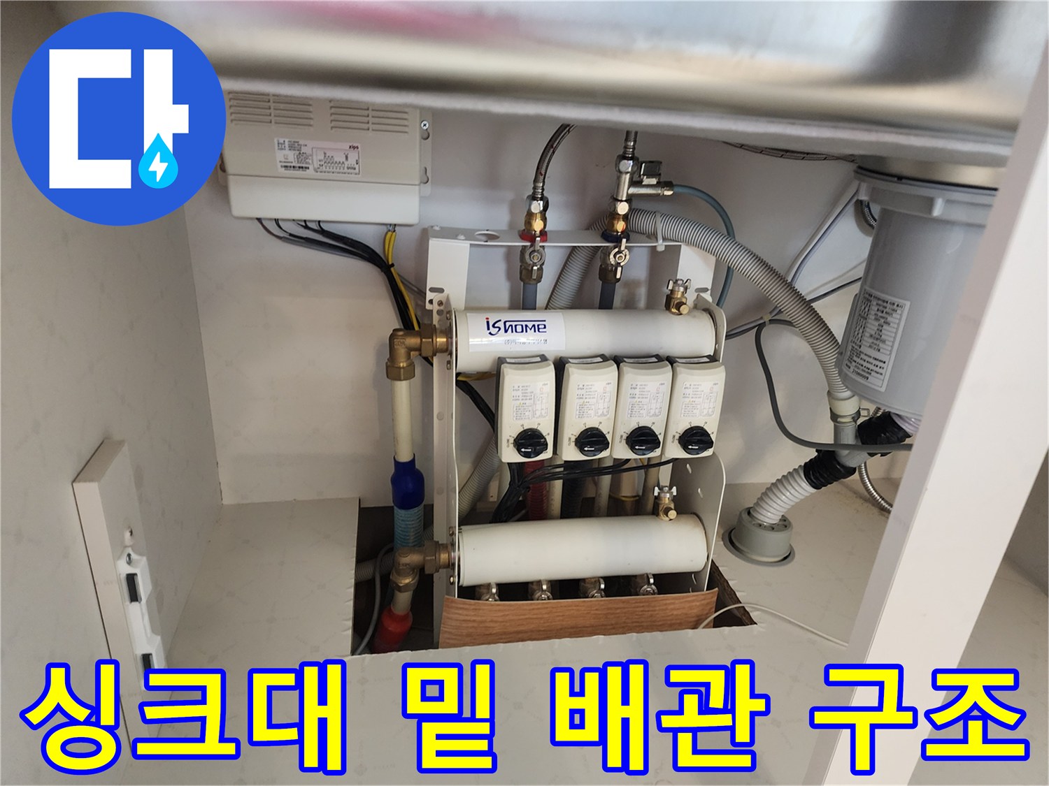주방 싱크대 아래 복잡하게 얽힌 수도 분배기 장치