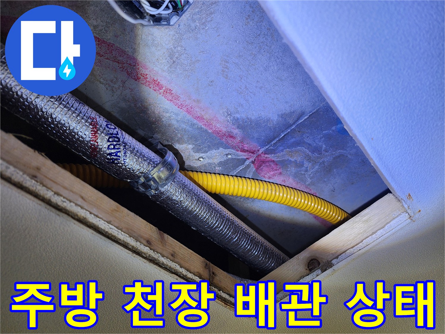 주방 싱크대 하부 천장면 - 은색 보온재와 노란색 주름관이 지나가는 모습