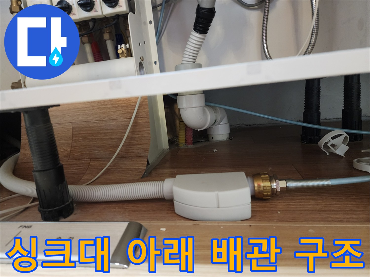 주방 하부장 내부에 복잡하게 설치된 급수 및 배수 배관