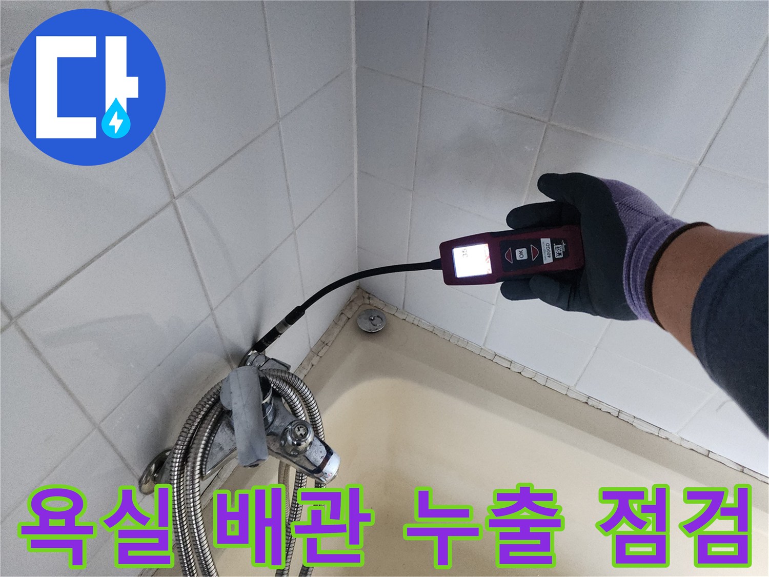욕조와 타일이 만나는-벽면 배관 연결부에서-누수 탐지기를 대고 있는 모습