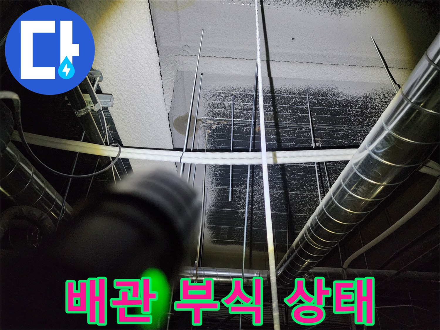 금속 배관 연결부의 부식과 누수 흔적을 촬영한 사진