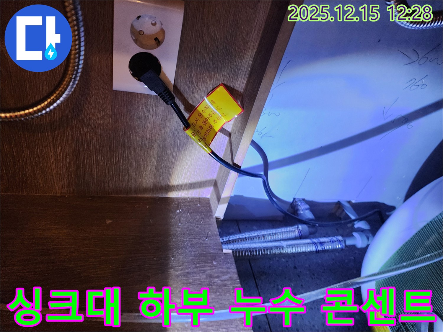 싱크대 하부에서 발견된 누수 흔적 - 콘센트 주변으로 물이 스며든 모습입니다.