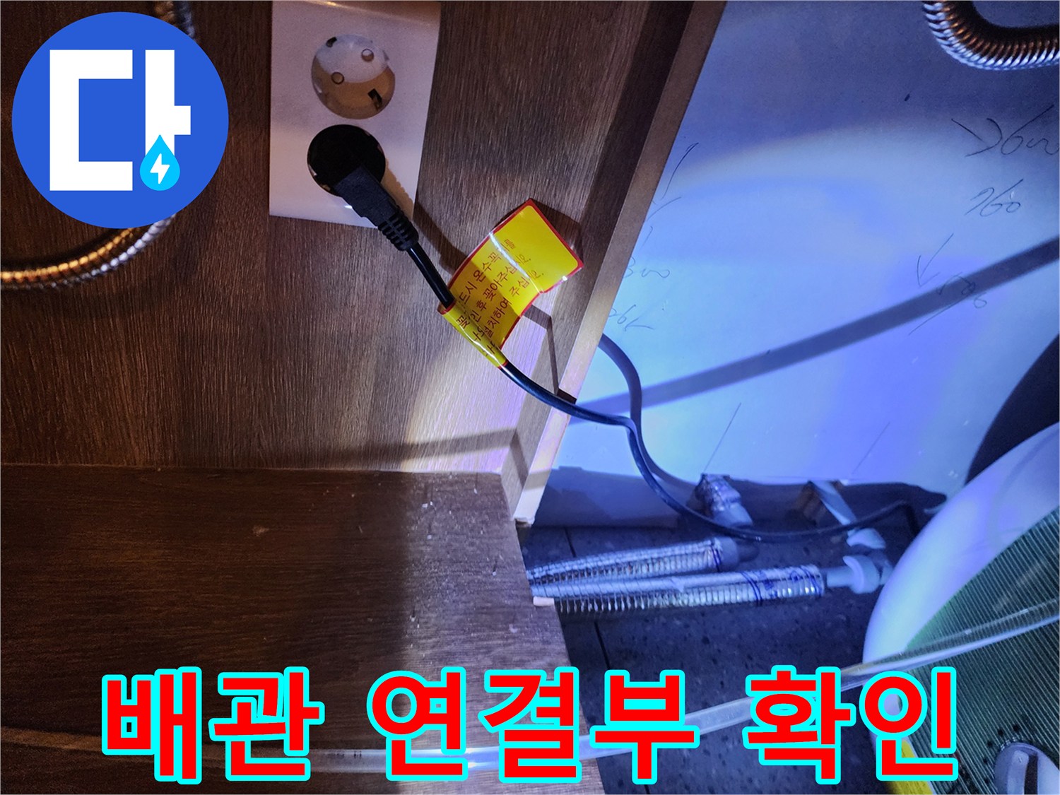 전기 온수기 전원선과 금속 배관이 만나는 하부장 내부 모습