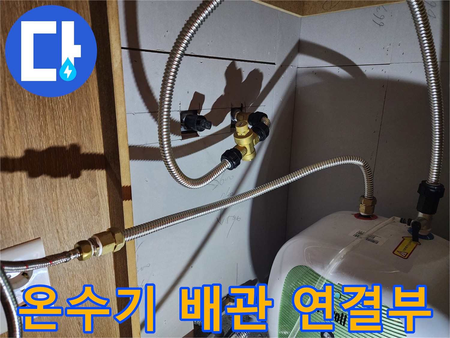 주방 하부장 내부-전기 온수기와 연결된 금속 호스의 상태
