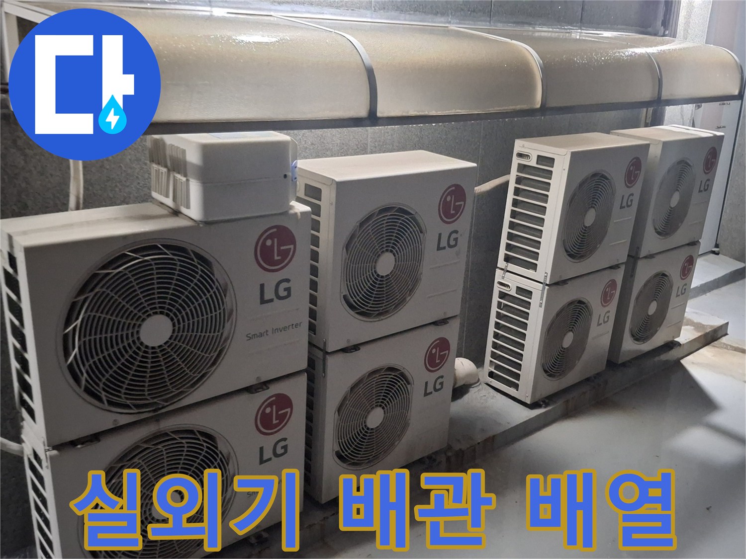 나란히 설치된 실외기와 아래로 연결된 배관들의 모습입니다.