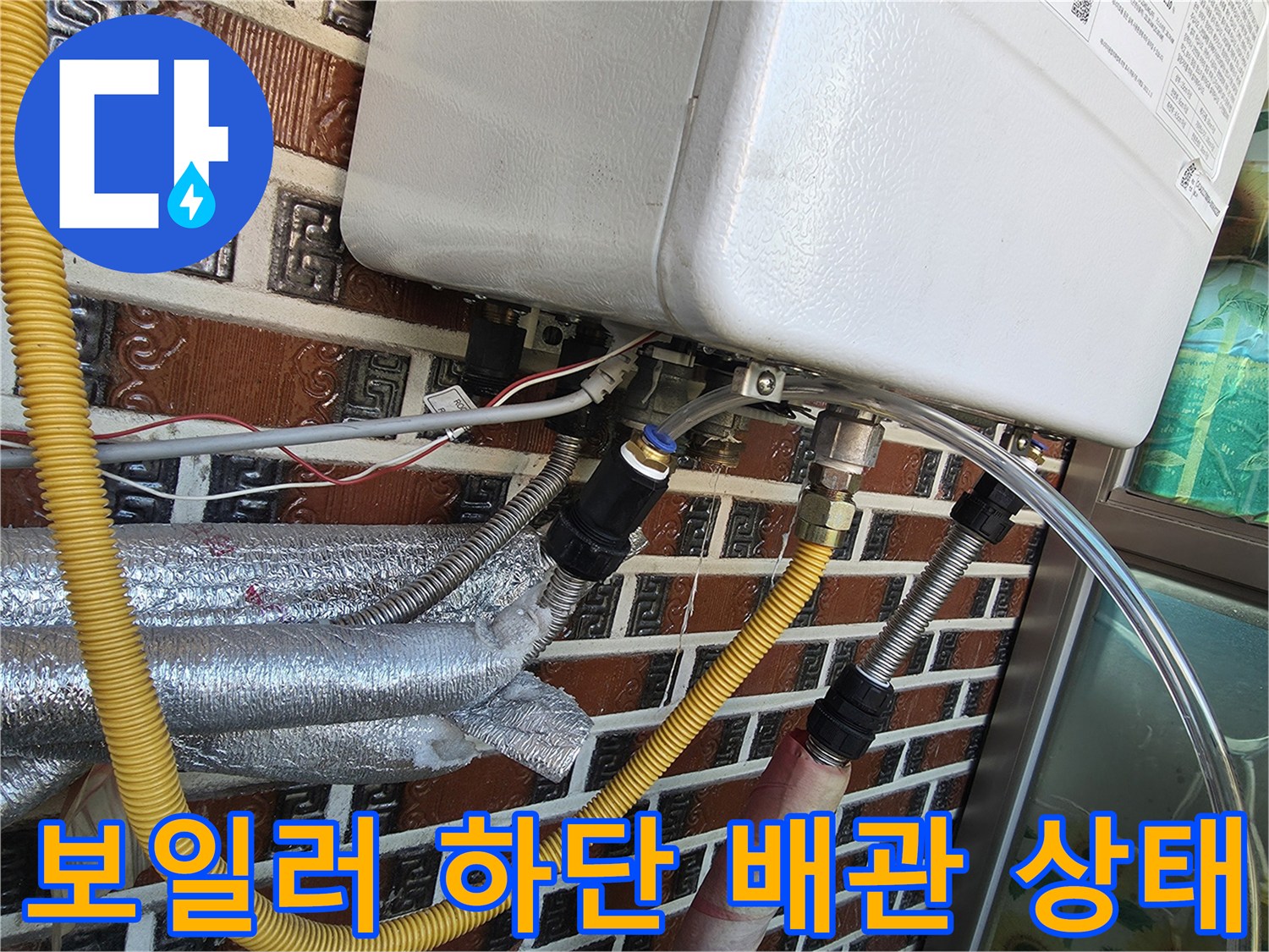 금속 연결 부품과 노란색 보온재가 씌워진 보일러 배관의 근접 사진