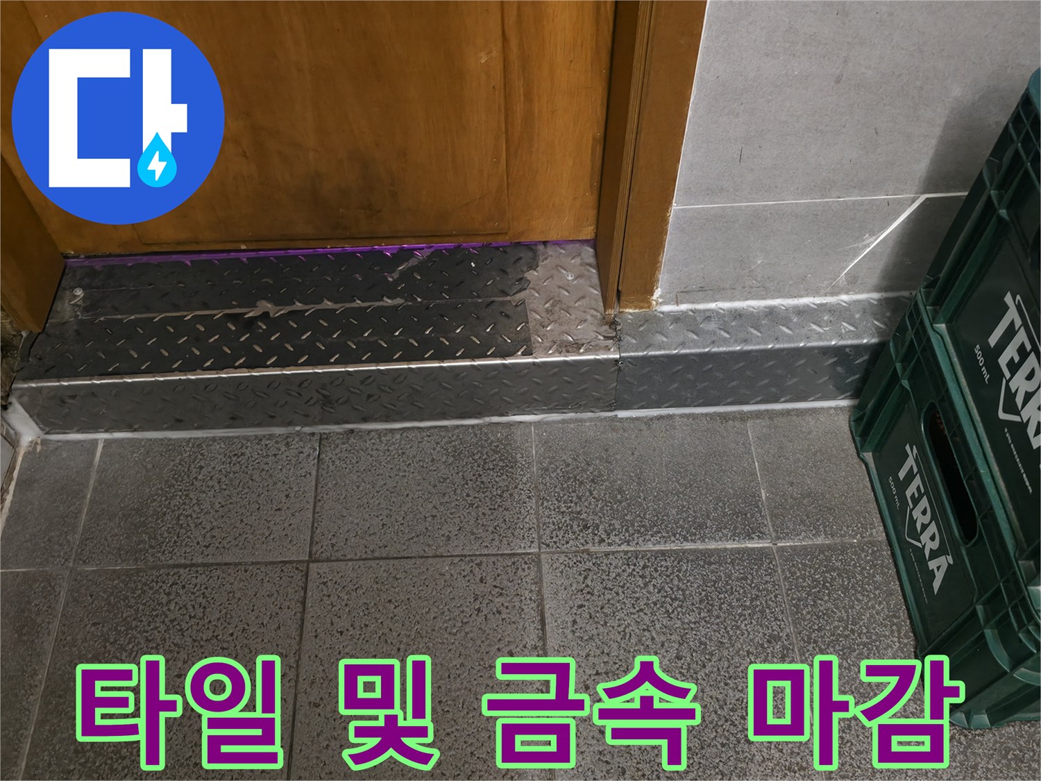 매장 내부 바닥 타일과 문턱 금속판의 접합부 사진