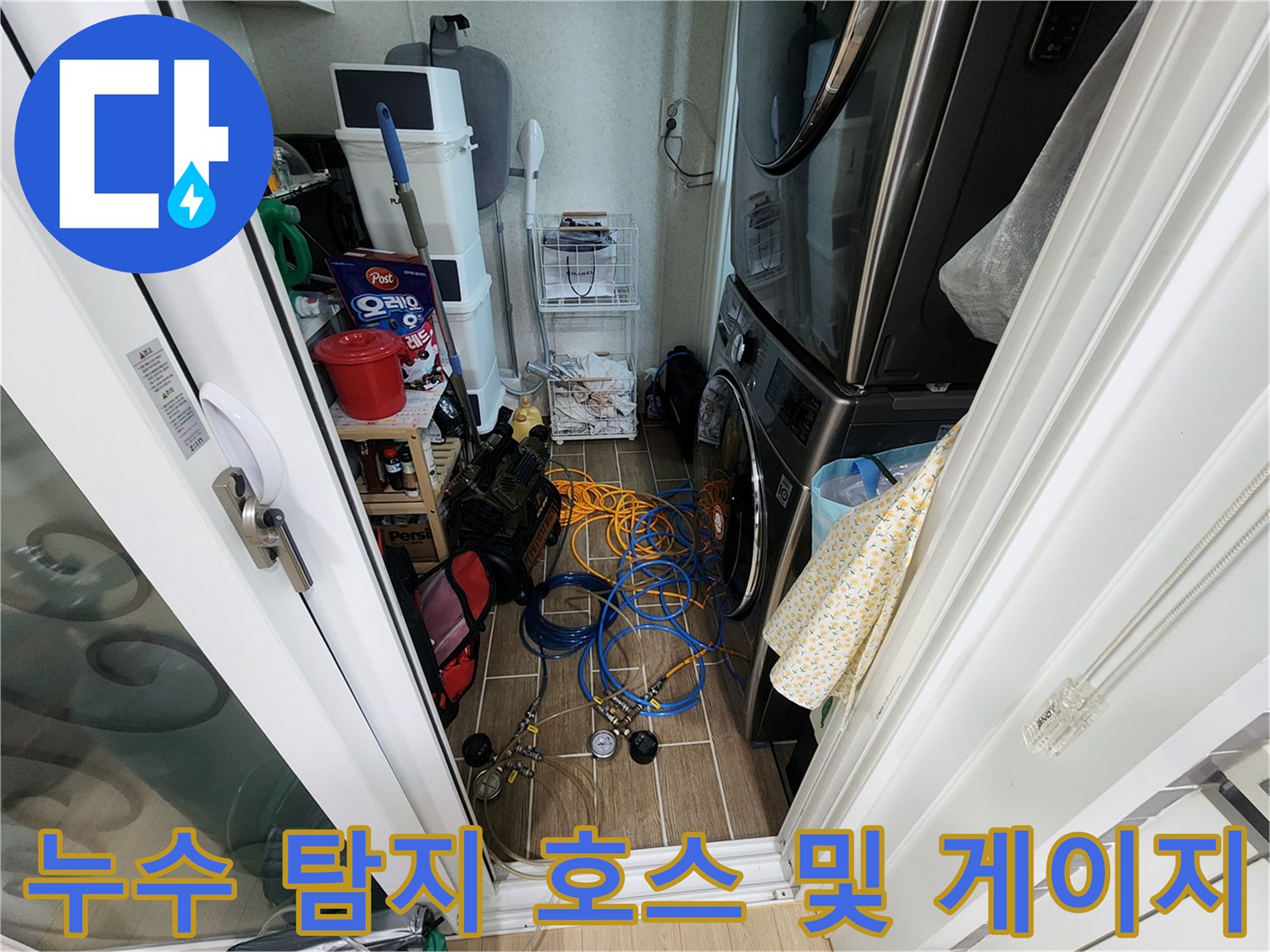 다용도실 바닥에 얽혀 있는 파란색 가스 탐지용 호스와 압력계 세트