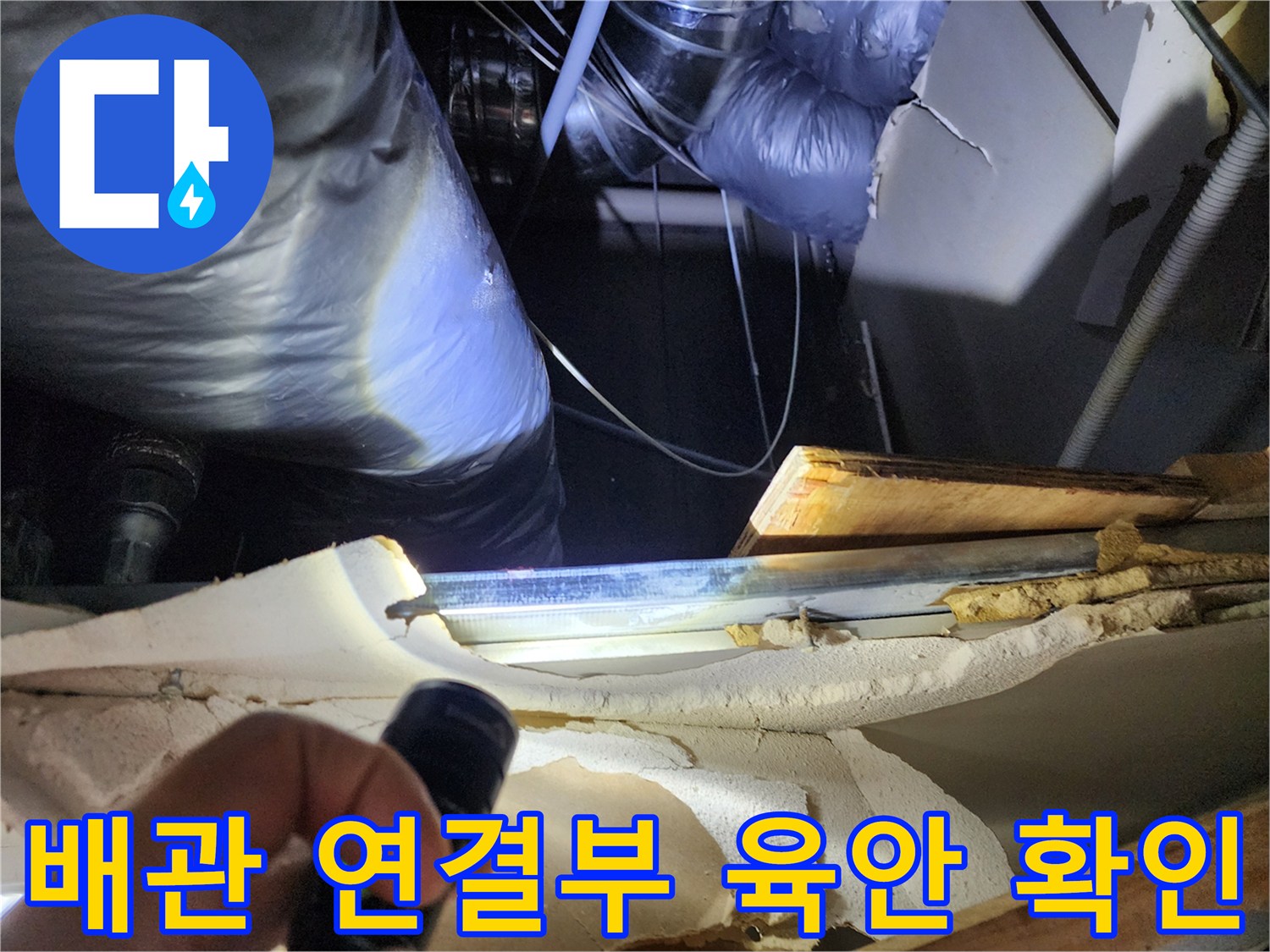 손전등으로 비춘 배관의 젖은 부위와 연결 구간