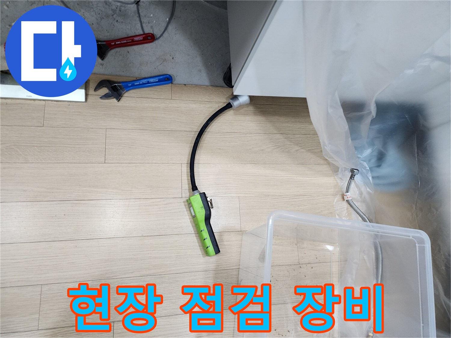 싱크대 아래 배관 누수를 확인하기 위한 가스 탐지기와 공구들