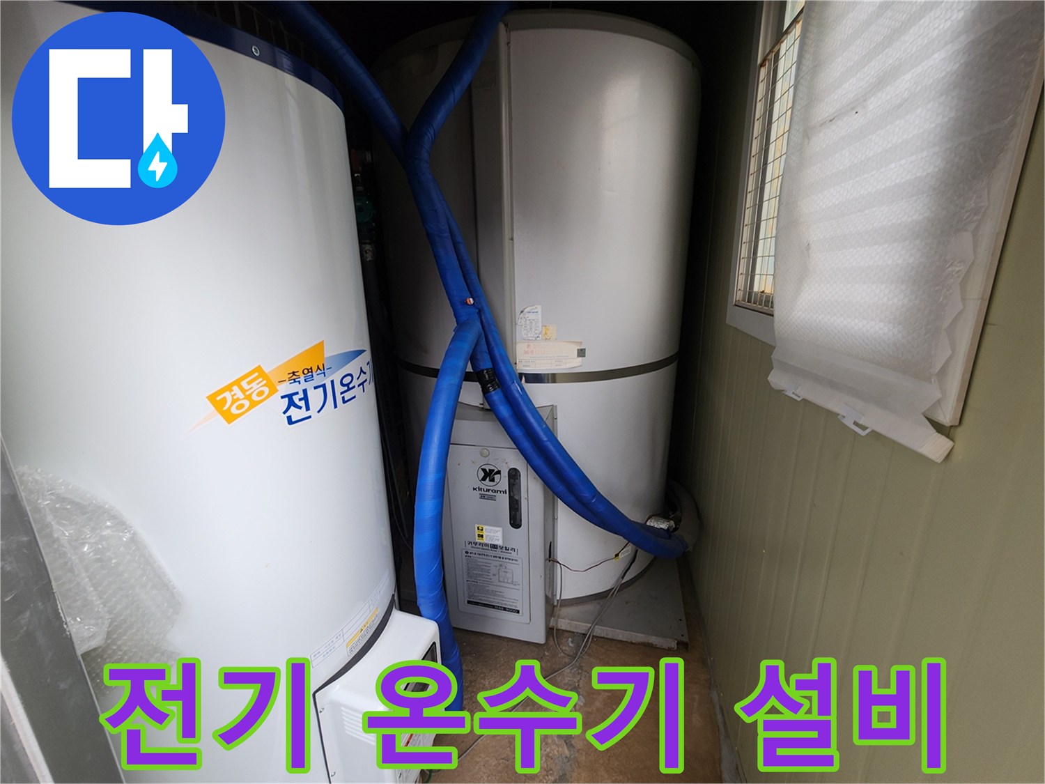 대형 전기 온수 탱크와 파란색 배관이 연결된 보일러실 내부 모습