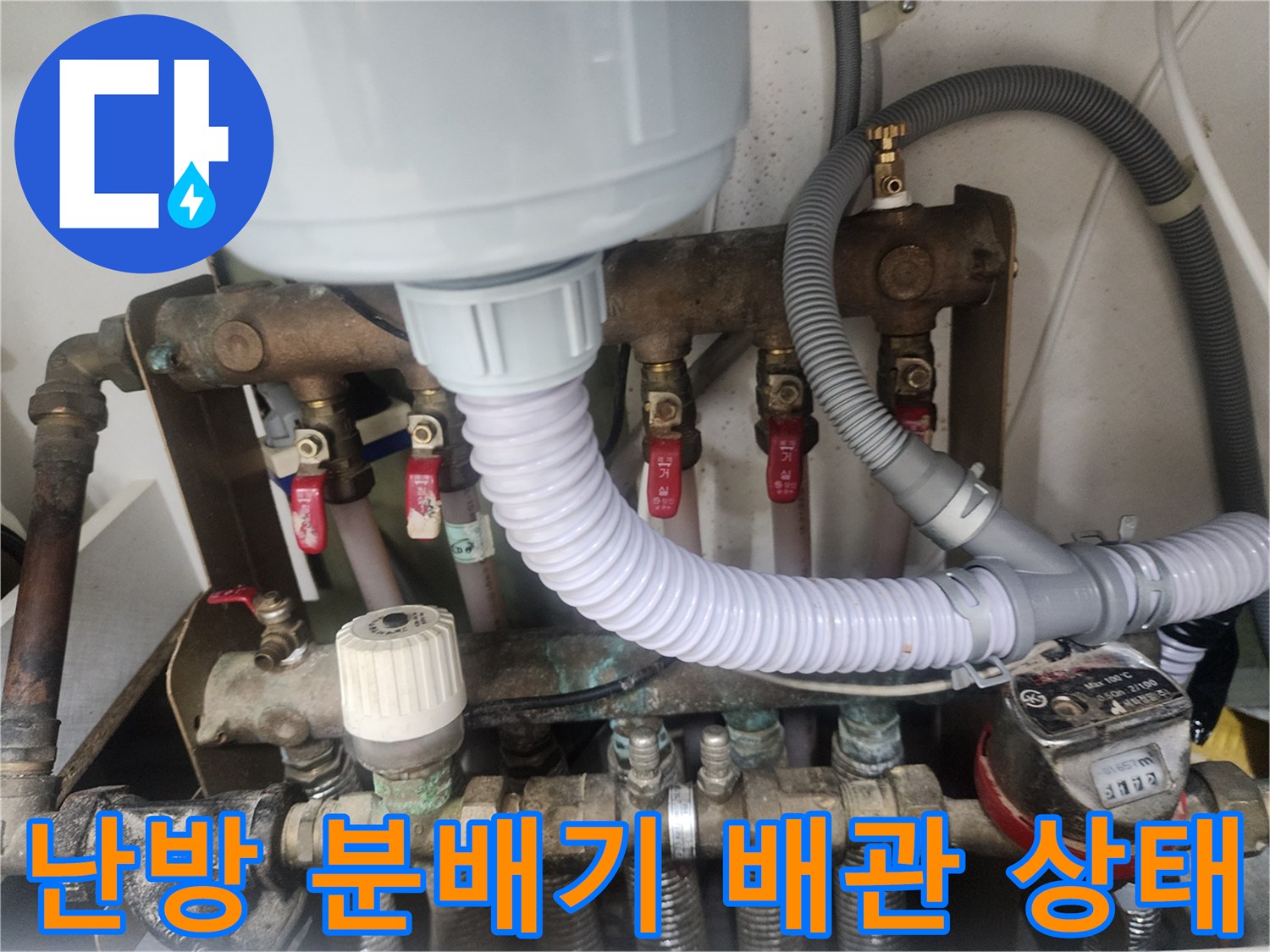 복잡하게 얽힌 난방 분배기의 금속 부품과 호스 연결 부위 사진