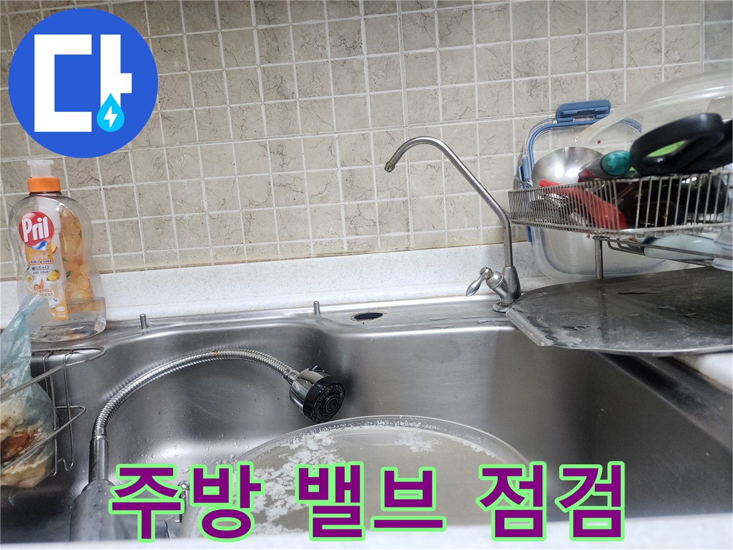 싱크대 아래쪽 수전 밸브와 연결 호스의 상태를 보여주는 사진입니다.