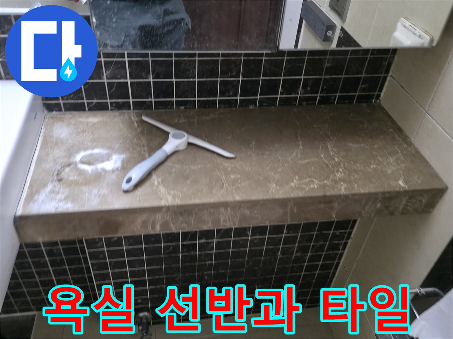 어두운 색상의 욕실 타일-세면대 옆 선반에 놓인 공구