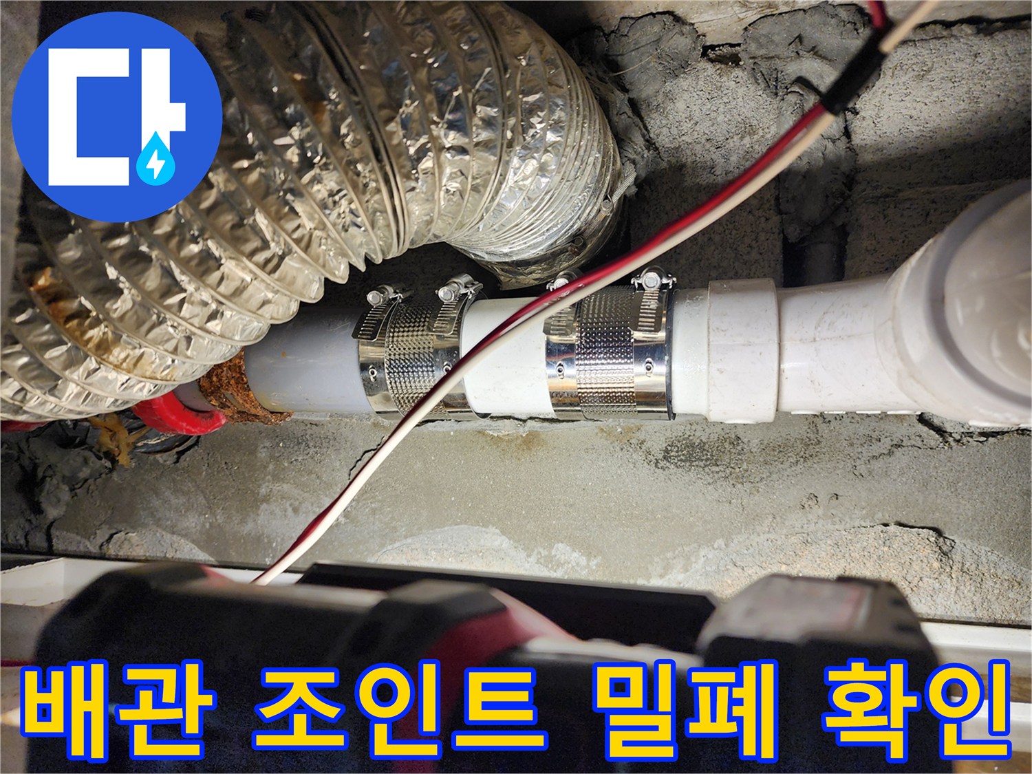 금속 클램프로 고정된 하수 배관의 연결 부위 근접 사진