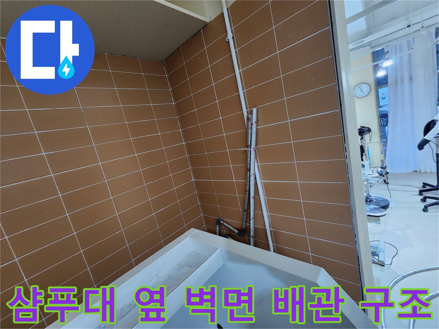 미용실 샴푸대 하단 타일벽과 노출된 배관 부위