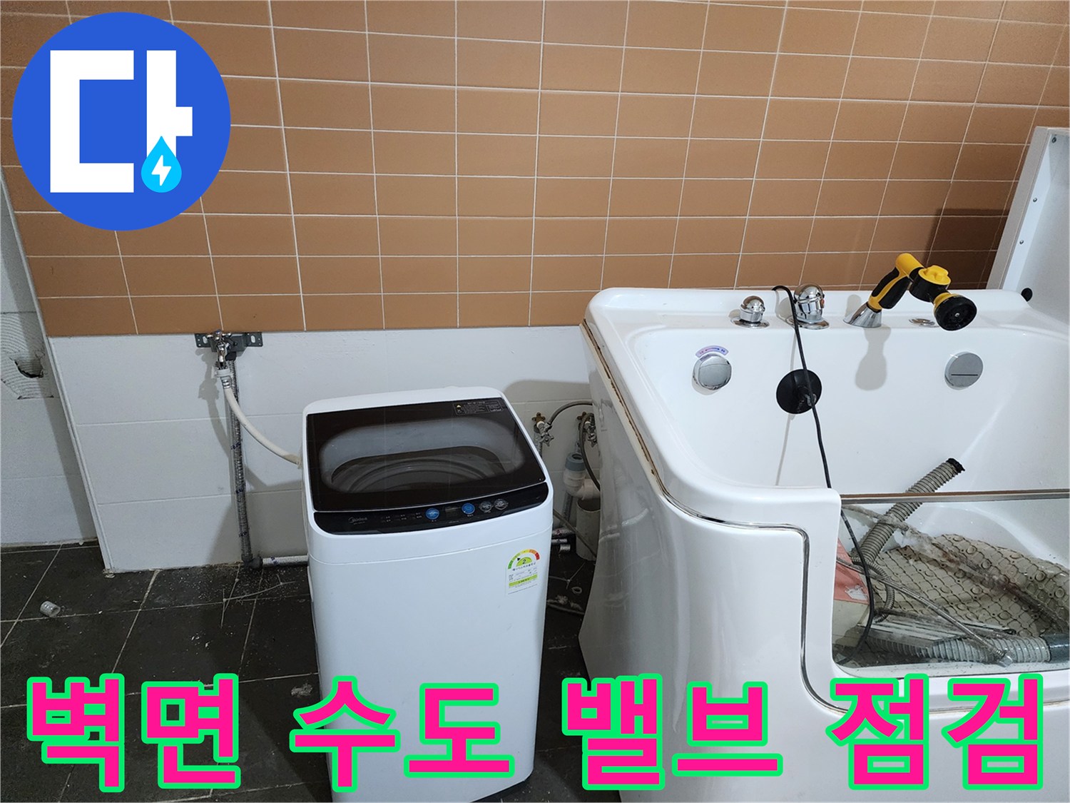 벽면 타일 부근의 급수 밸브와 세탁기 호스 연결 상태를 촬영한 이미지