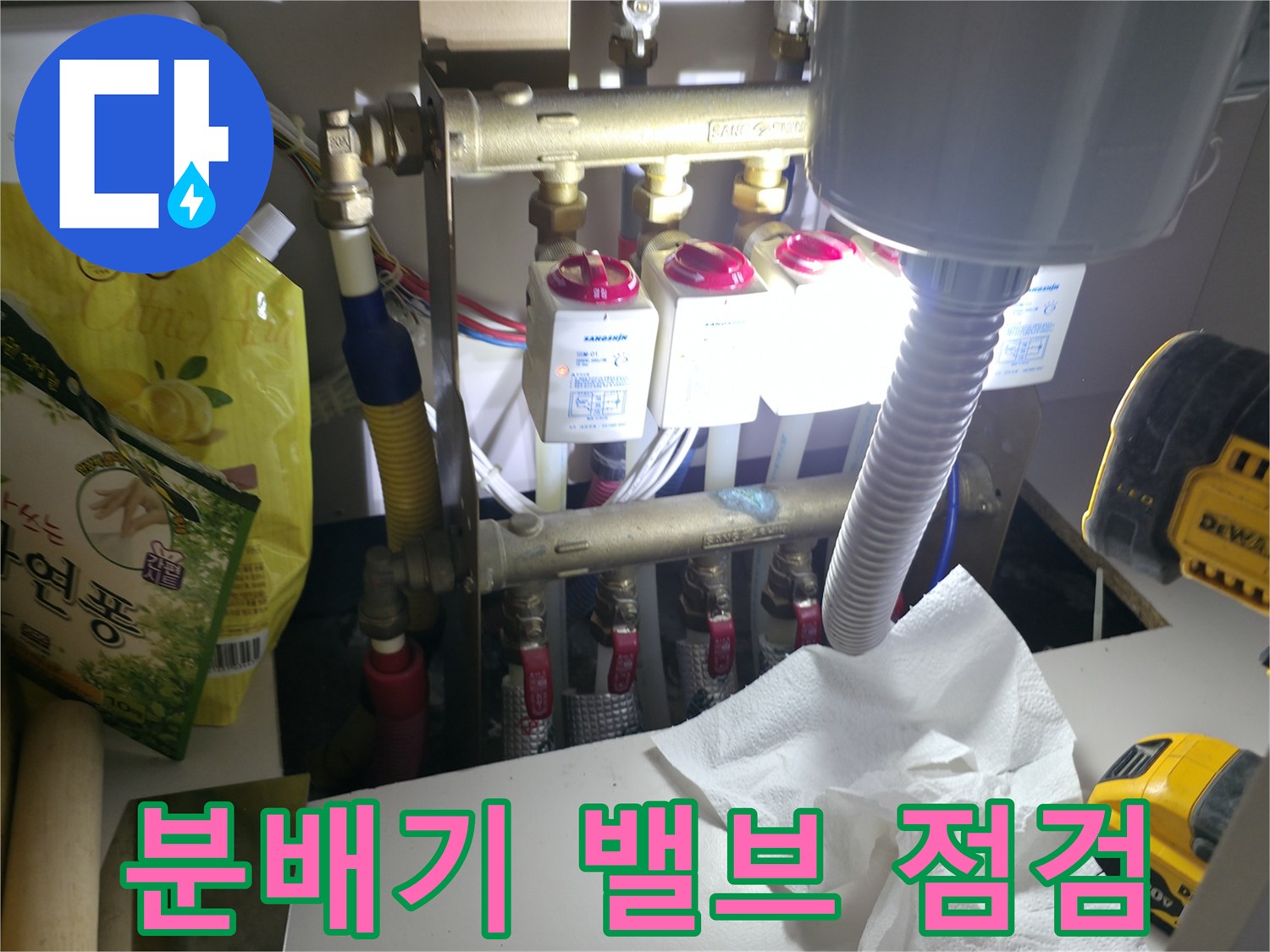 가스 탐지 장비와 배관 분배기가 보이는 싱크대 하단 작업 현장