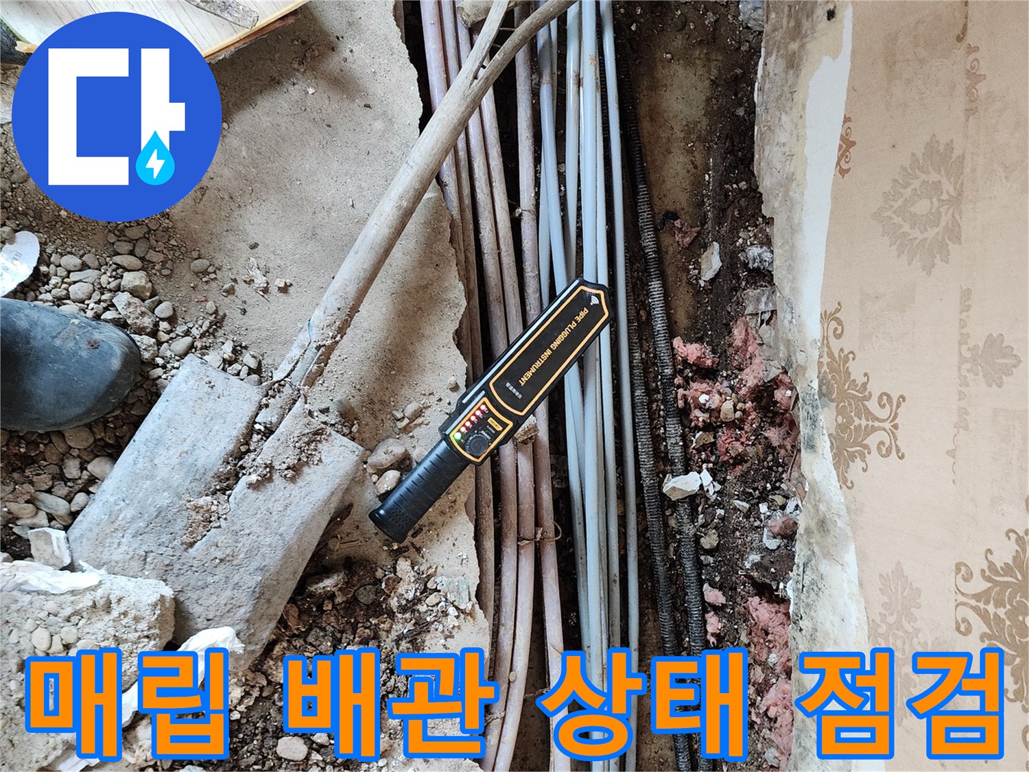 벽면 굴착 부위-손상된 배관과 탐지 장비가 놓인 현장