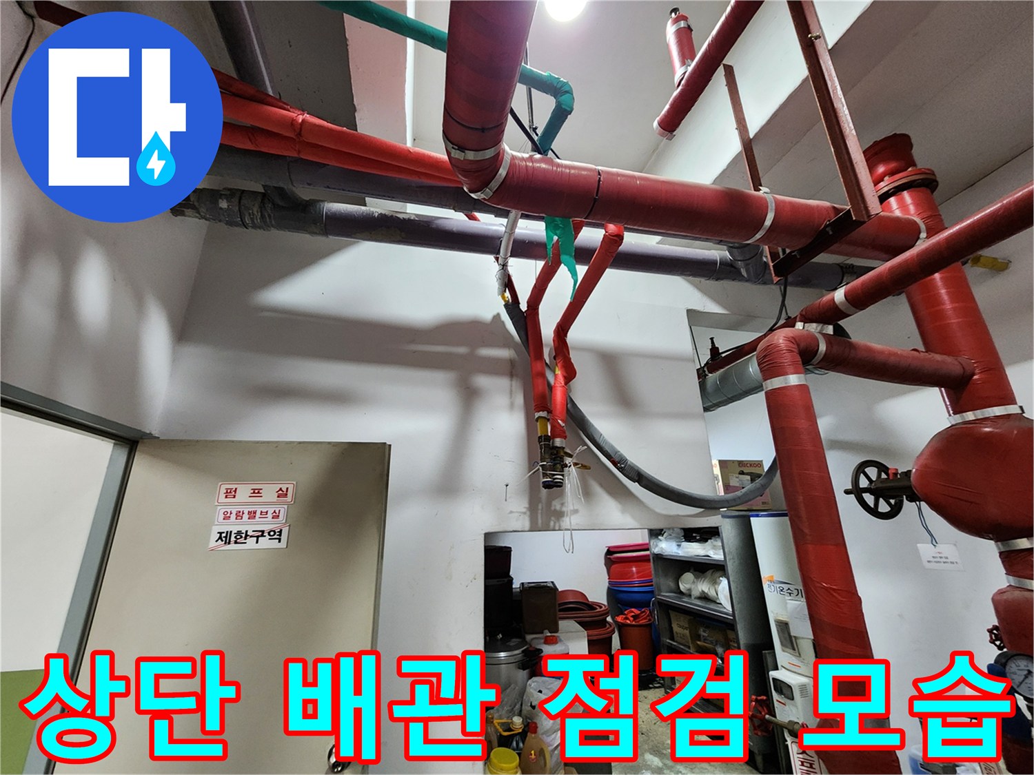 천장에 설치된 붉은색 배관과 밸브 장치 근처의 작업 현장