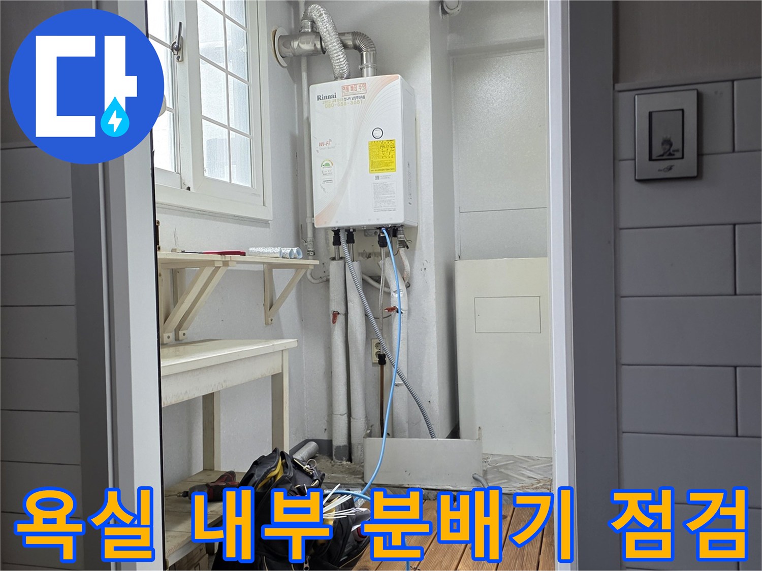 아파트 욕실 벽면에 노출된-온수 분배기와 연결된 배관들