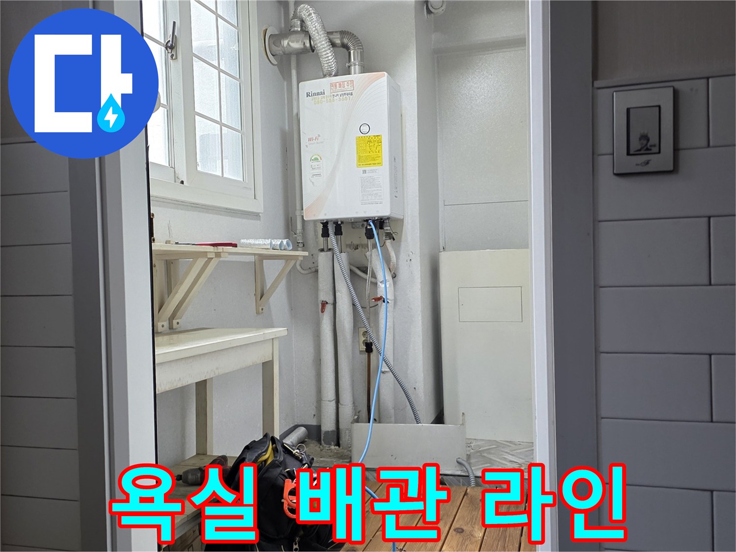 욕실 벽면에 설치된 온수 분배기와 연결된 수도 호스들