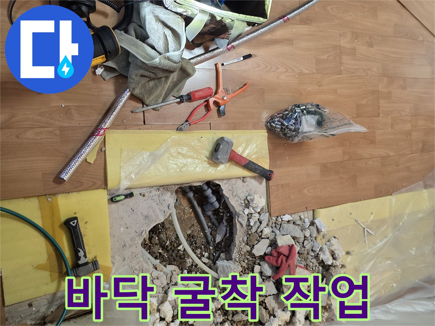 바닥을 파헤쳐 배관이 드러난 모습과 공구들이 놓인 현장