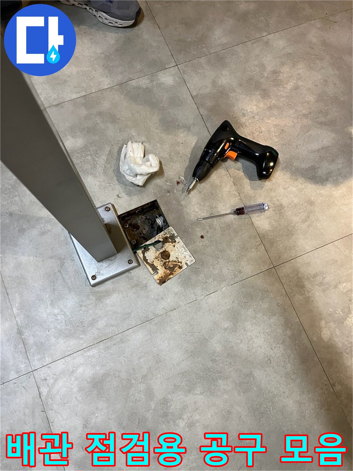 현장에서 사용된 전동 드라이버와 분해된 바닥재 부품