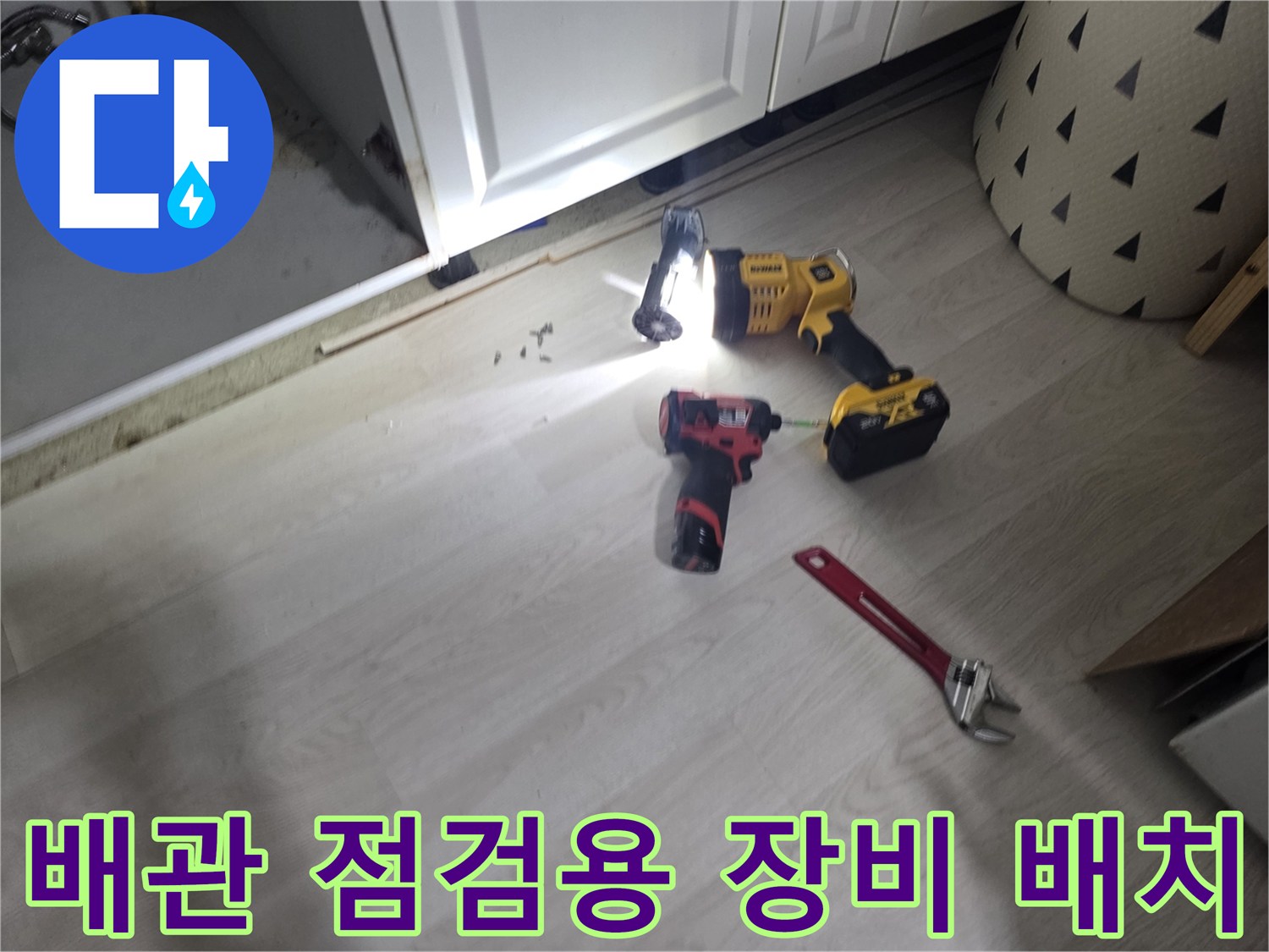 작업을 위해 바닥에 놓인 랜턴과 몽키스패너와 드릴