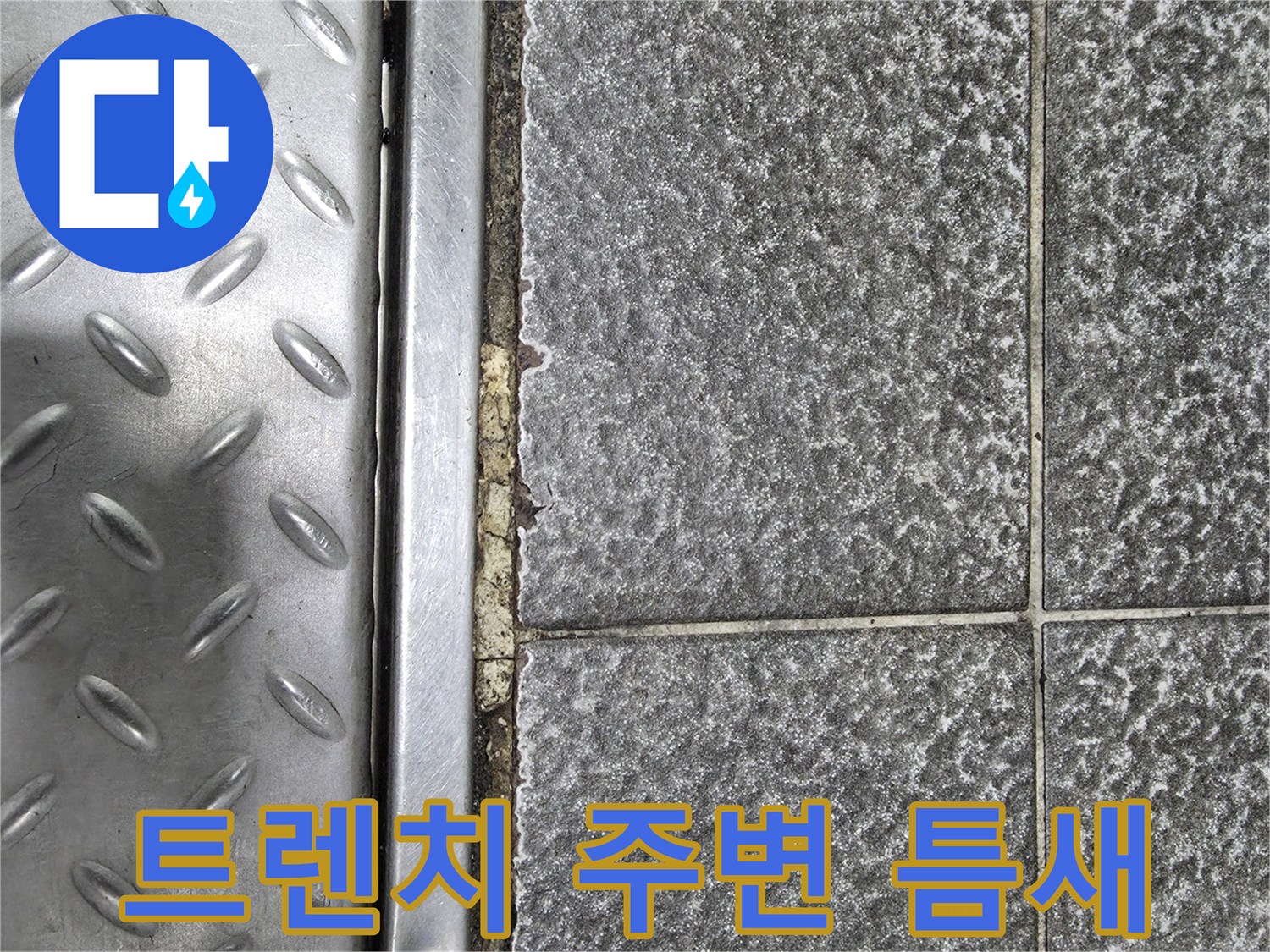 금속 트렌치 덮개와 회색 타일 사이의 균열 부위