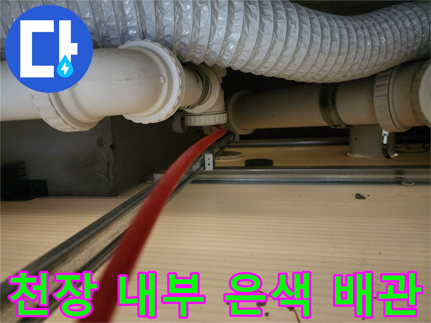 천장 안쪽의-은색 주름관과 하얀색 PVC 배관 연결부
