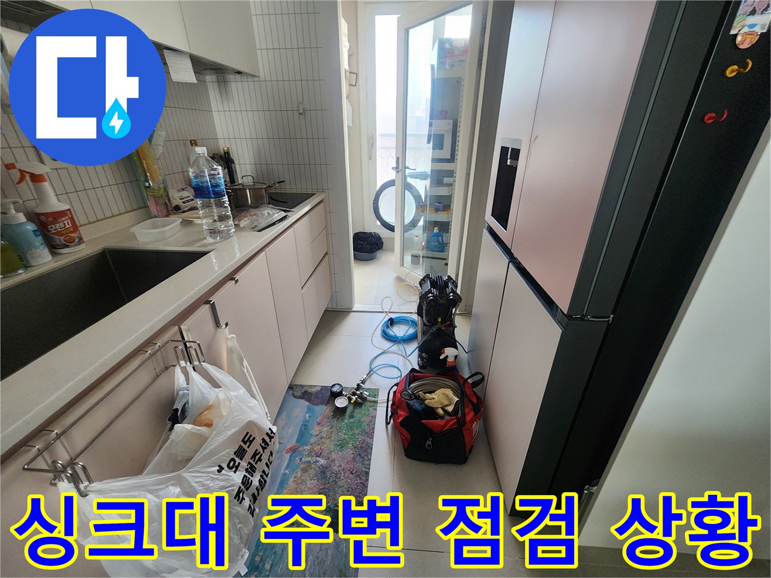 주방 싱크대 하부와 작업 도구가 놓인 현장 모습