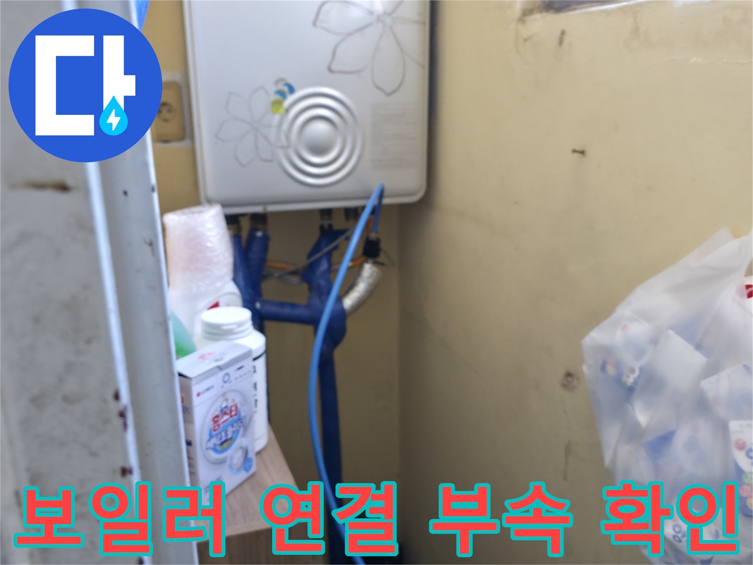 보일러 하단에 연결된 파란색 배관과 금속 부속품들