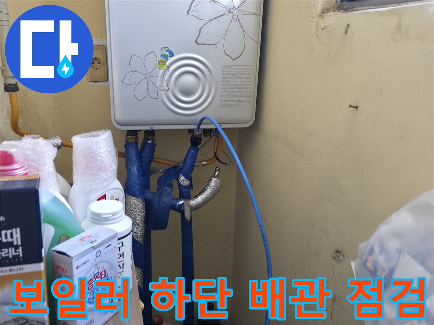 흰색 보일러 본체와 연결된 파란색 및 금속 배관들