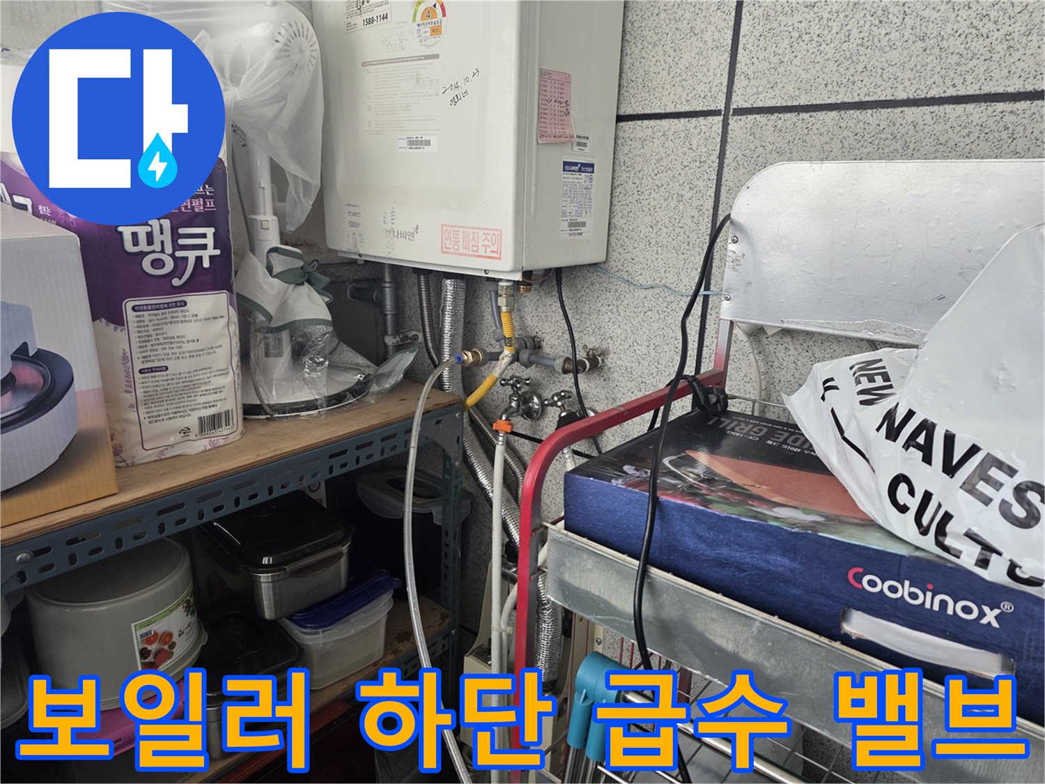 보일러 아래쪽의 금속 부품과 연결된 수도 배관 모습